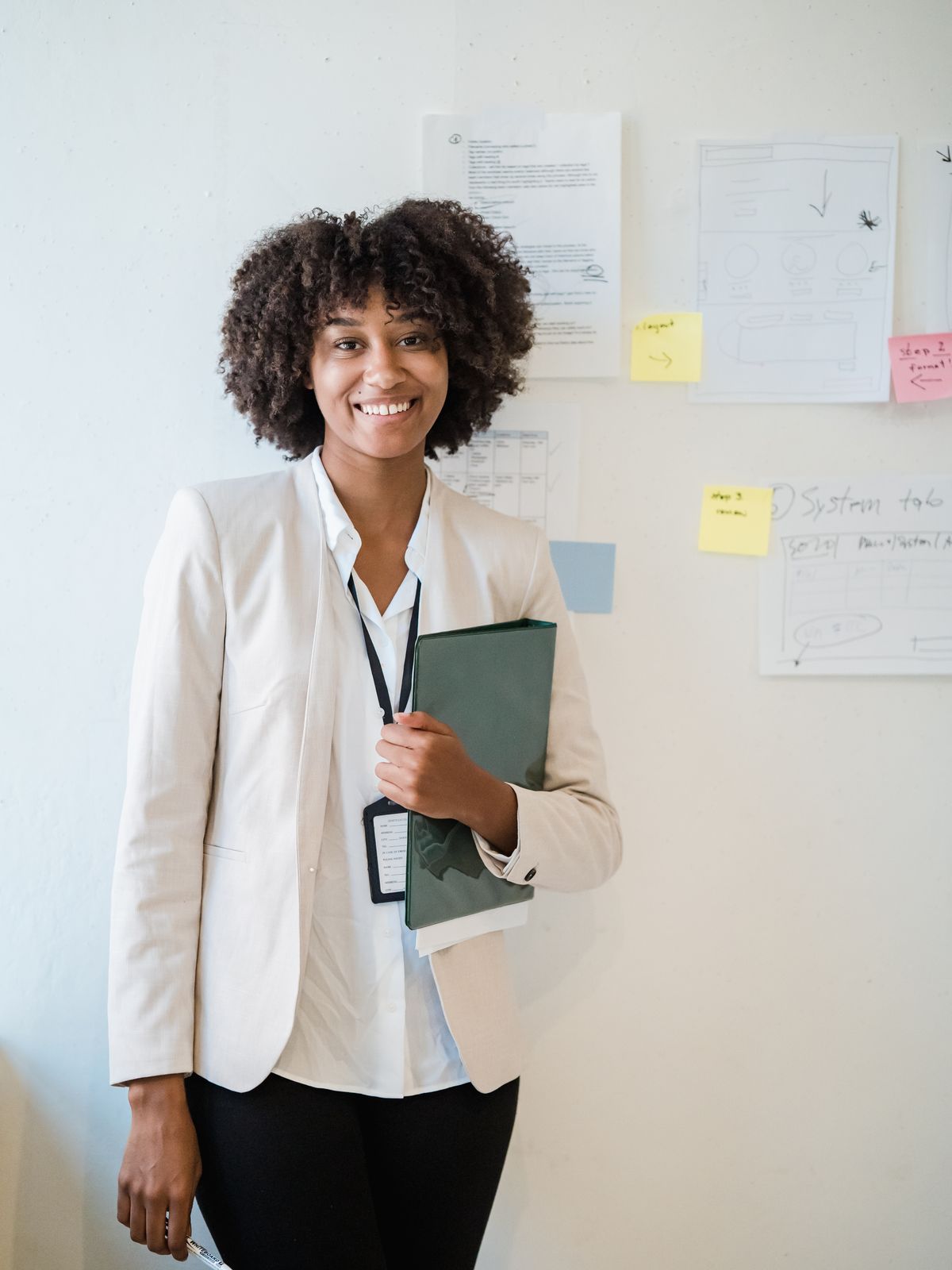 Recruitment consultant holding a folder beside a planning wall